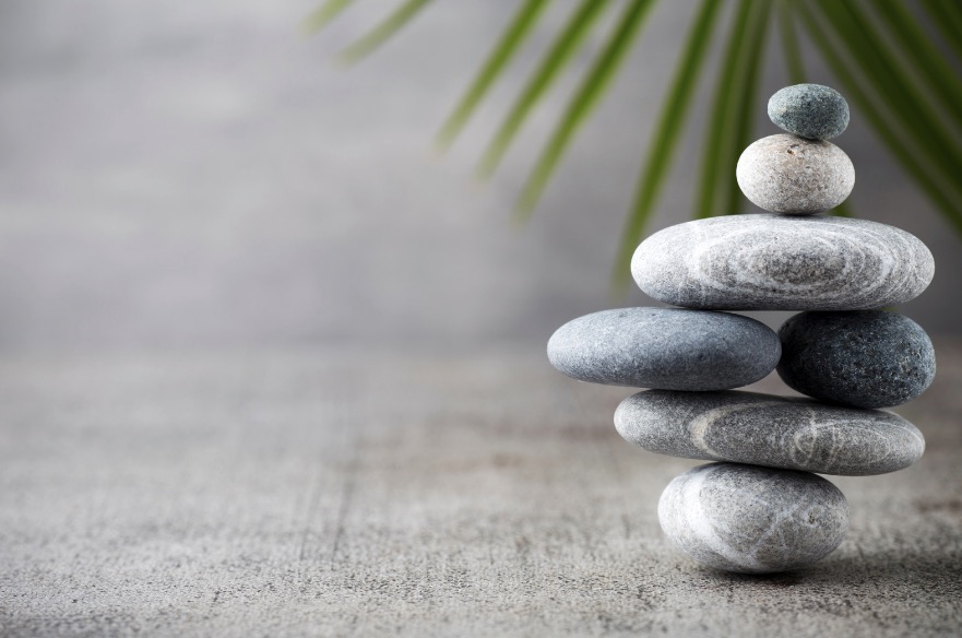 Balanced stones with a palm leaf